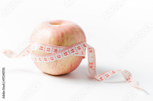 Measuring tape wrapped around apple as a symbol of diet.
