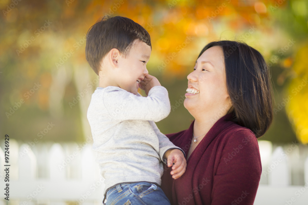 Fototapeta premium Happy Chinese Mom Having Fun and Holding Her Mixed Race Little Boy.