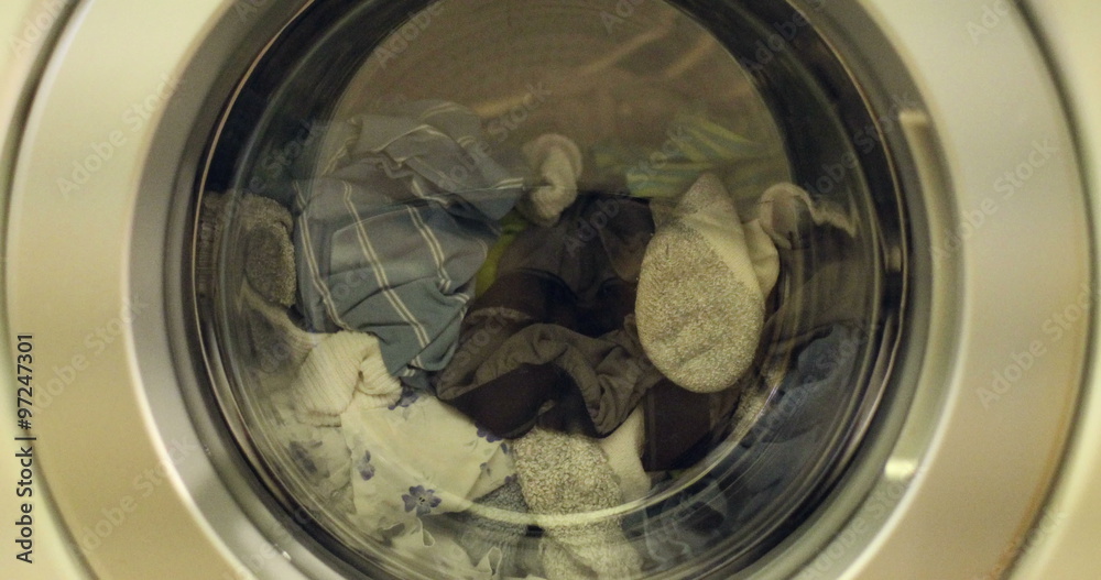 Clip of a high efficiency washing machine (side loader) washing laundry starting up after being closed Clip of a high efficiency washing machine (side loader) washing laundry starting up after being closed