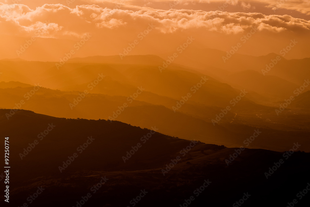 mountains silhouette at sunset with fog