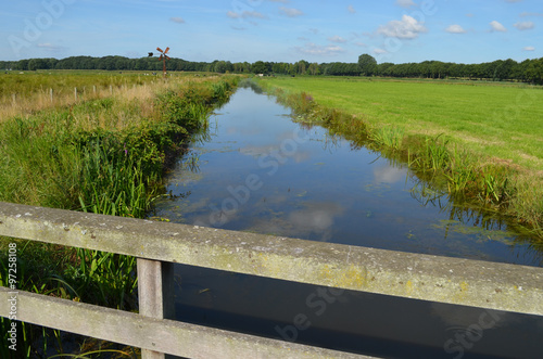 Fototapeta Ditch and green meadow in Dutch polder in summer, Breda, seen from bridge