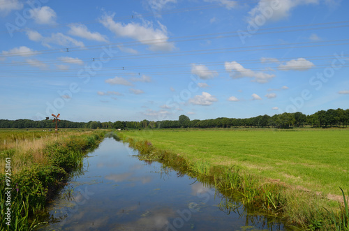 Ditch and green meadow in Dutch polder in summer, Breda