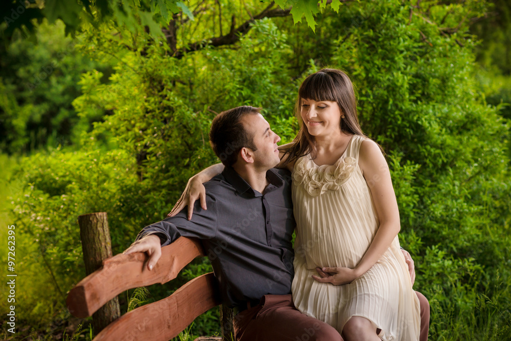 A pregnant woman and her partner sitting A pregnant woman and her partner sitting