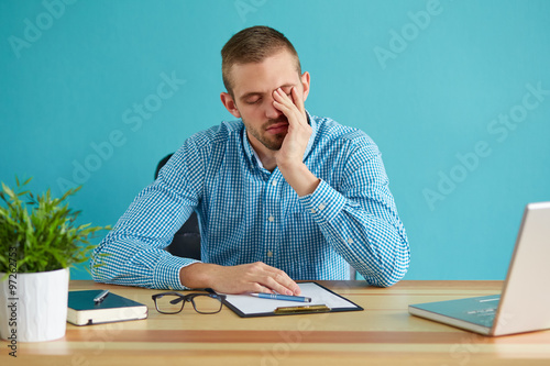 Businessman rubbing his eye