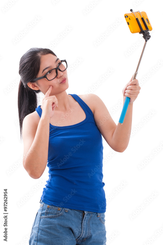 Young woman taking picture with smartphone selfie stick Young woman taking picture with smartphone selfie stick