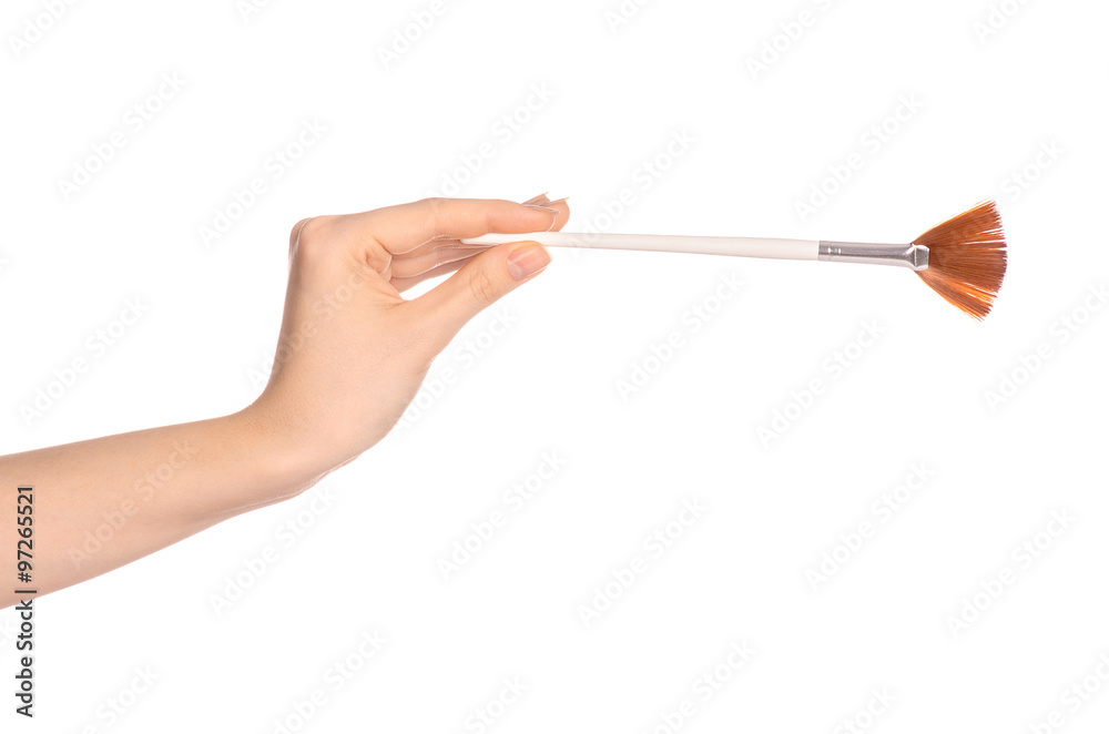 Makeup and beauty topic: a woman's hand holding a brush makeup isolated on white background in studio Makeup and beauty topic: a woman's hand holding a brush makeup isolated on white background in studio