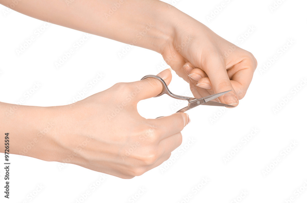 Health and personal care: female hand holding scissors for manicure isolated on white background in studio Health and personal care: female hand holding scissors for manicure isolated on white background in studio