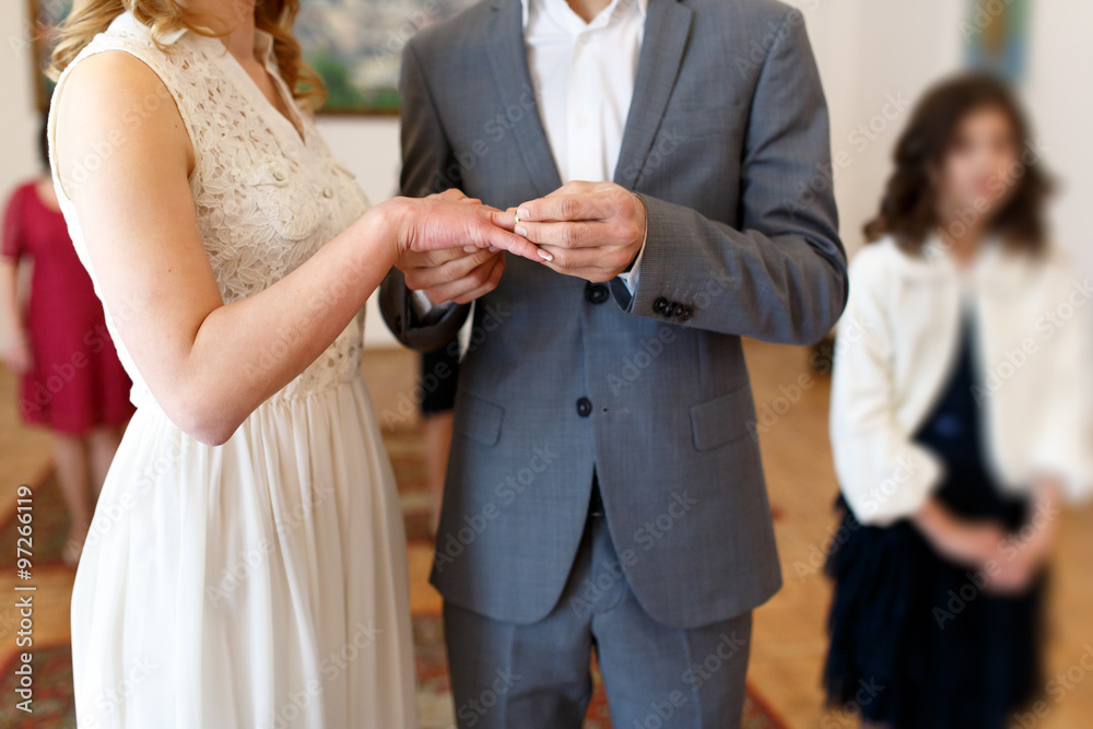 wedding couple bride and groom putting on ring hands close-up