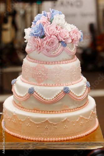 Expensive, elegant vintage wedding cake with flowers and ornaments close-up