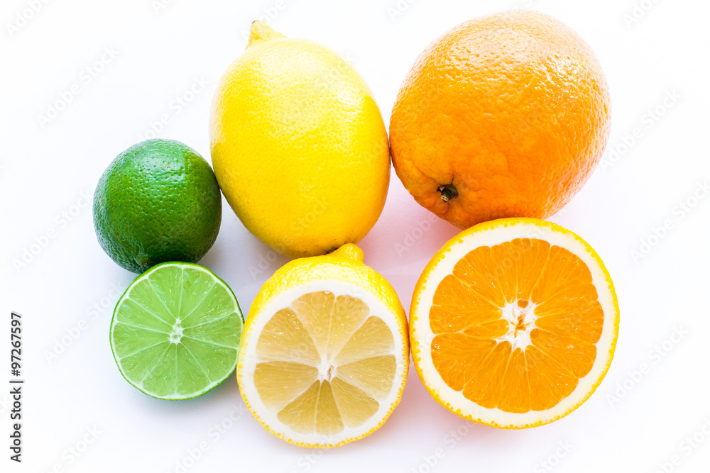 Close up photo of one cut-in-half slice of lime, lemon, an orange, with one  whole lime, lemon, an orange behind. The background is isolated.