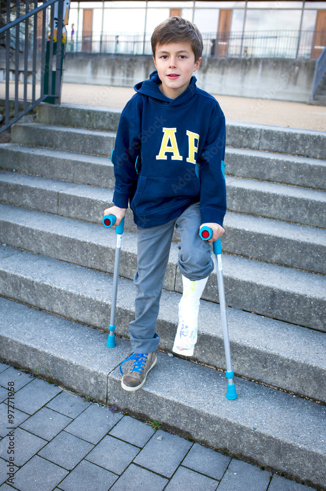 Junge mit Gipsbein und Krücken steigt eine Treppe runter Stock Photo |  Adobe Stock