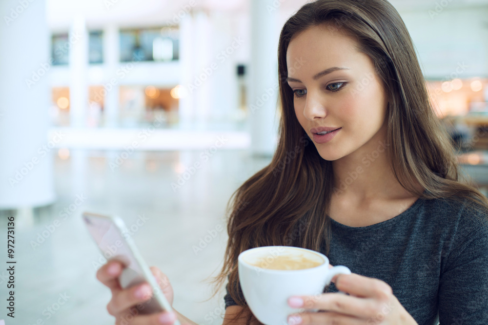 woman with cup of coffee in the restaurant calling by cellphone woman with cup of coffee in the restaurant calling by cellphone