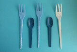 Blue and white fork and spoon on blue background - party time concept