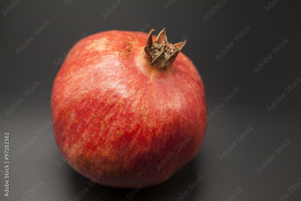 Spanish juicy ripe pomegranate closeup on a dark background Spanish juicy ripe pomegranate closeup on a dark background