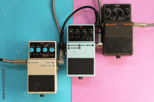 Guitar pedals on half blue half pink background - music concept