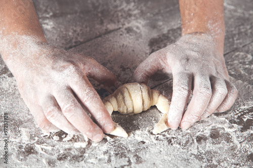Detail of hands preparing french croissant