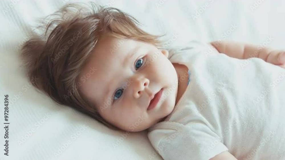 Closeup face of a happy newborn baby girl boy. Smiling at camera. Top view Closeup face of a happy newborn baby girl boy. Smiling at camera. Top view