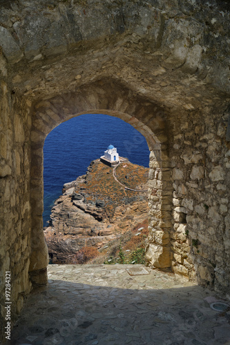 Small church through old castle on Santorini island, Greece