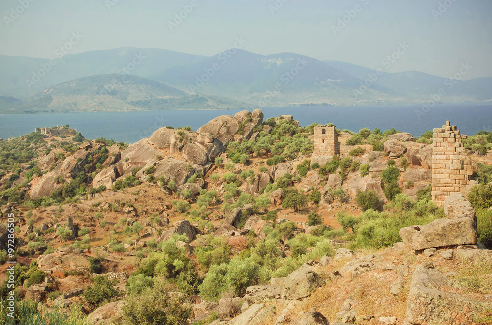 Landscape with ruins of Byzantine town over the lake, nature reserve of Turkey with olive trees and mountains around