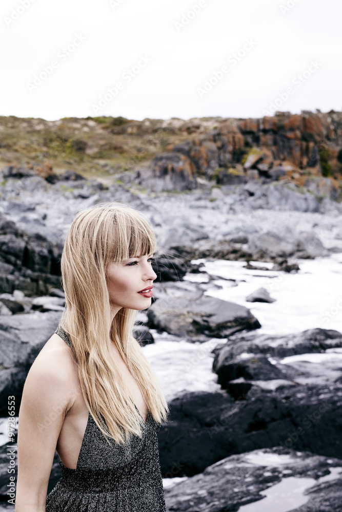 Beautiful blond woman in gray dress, outdoors