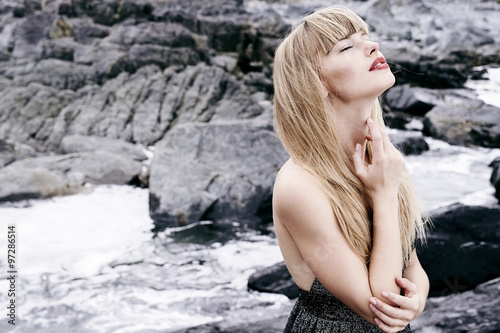 Serene young woman amongst rocky landscape