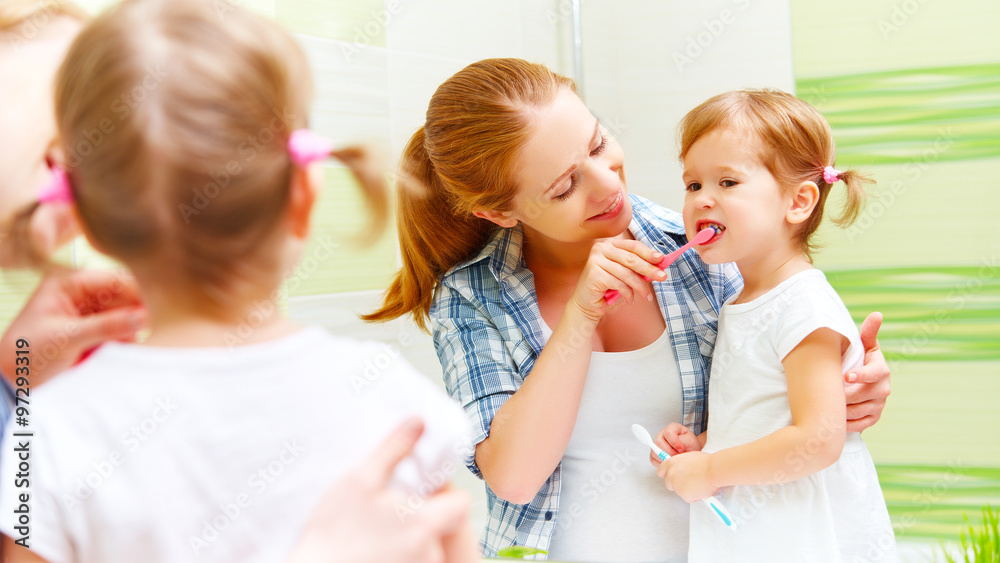 happy family mother and child girl cleans teeth with toothbrush