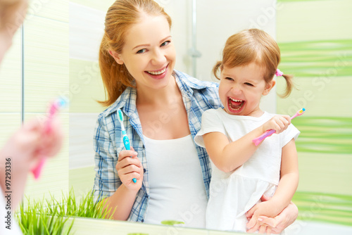  happy family mother and child girl cleans teeth with toothbrush