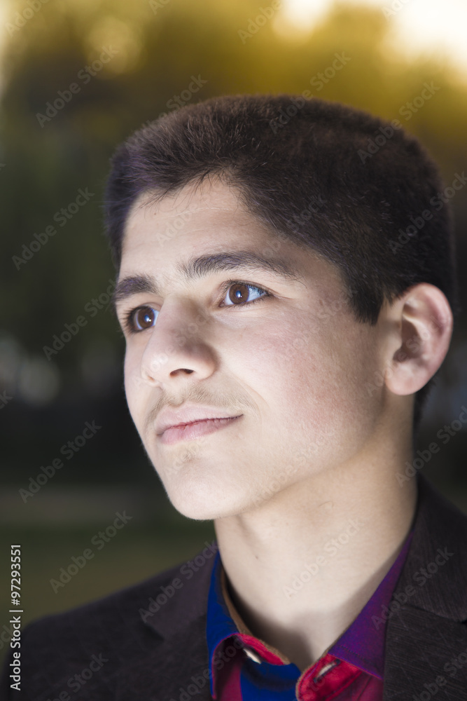 Headshot of white Iraqi boy lit by back light 