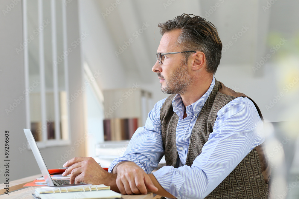 Businessman at home looking away through window Businessman at home looking away through window