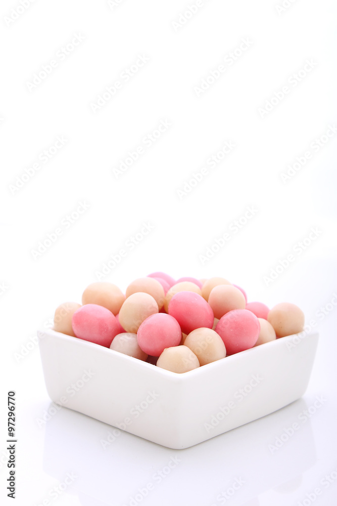 Fototapeta premium pink and white candy in a round white plate on a white background