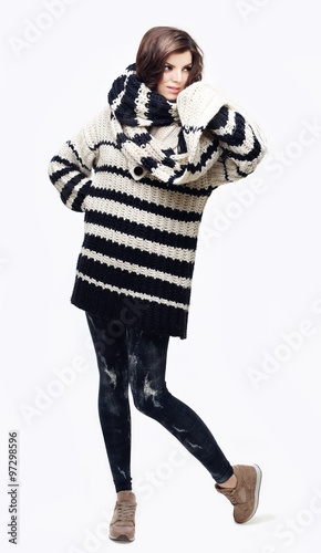 Portrait of a beautiful young adult woman wearing a sweater and scarf, looking at the camera