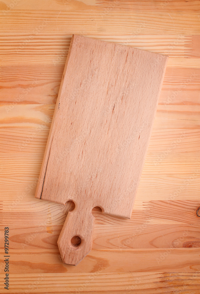 light wooden cutting board on a wooden background