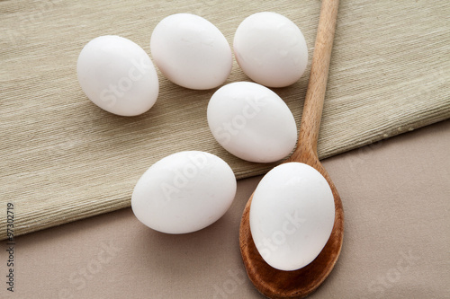 Fresh eggs on a wooden spoon