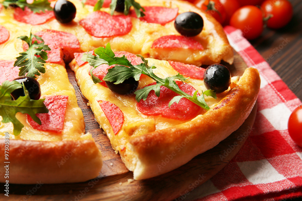 Delicious tasty pizza with salami and olives on wooden background, close up Delicious tasty pizza with salami and olives on wooden background, close up