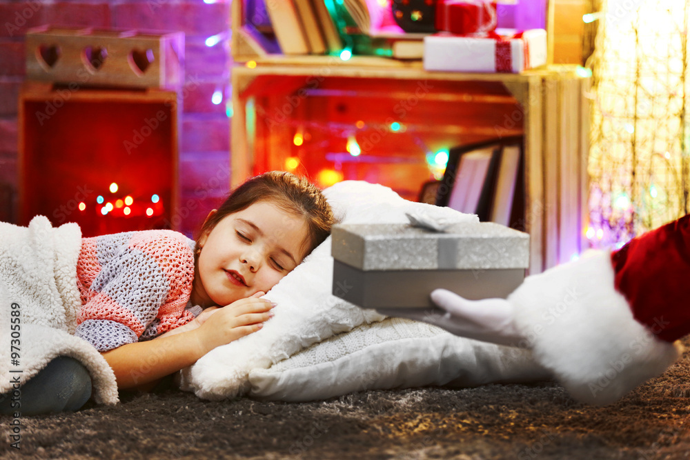 Obraz premium Pretty little girl laying on the pillow under soft plaid waiting for Santa's gift in Christmas decorated room