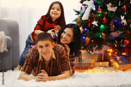 Happy family on the floor in the decorated Christmas room