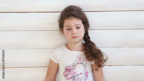 sad girl standing at a white wall