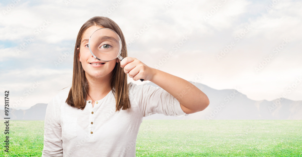 portrait of young girl looking through a magnifying glass