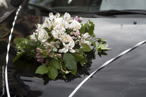 bouquet of flowers on the hood of wedding 
