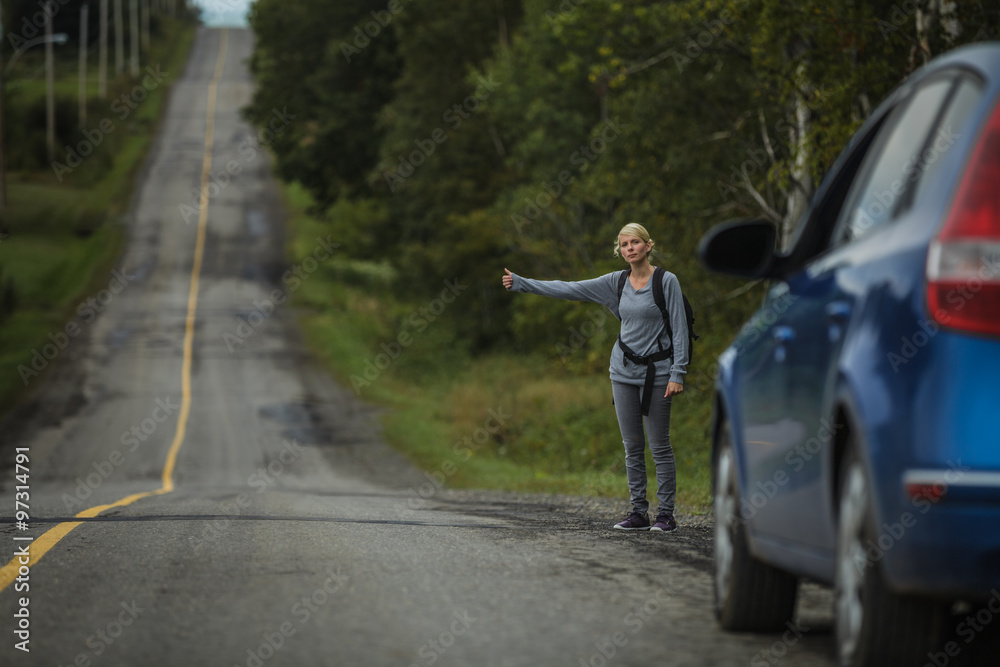 Blonde Woman Hitchhiking on the Side of the Road Blonde Woman Hitchhiking on the Side of the Road