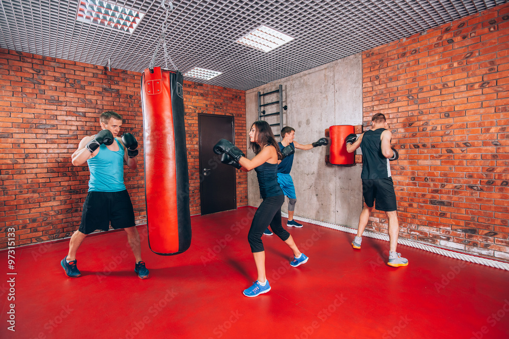 Boxing aerobox group with personal trainer man at fitness gym, gloves, punching bag