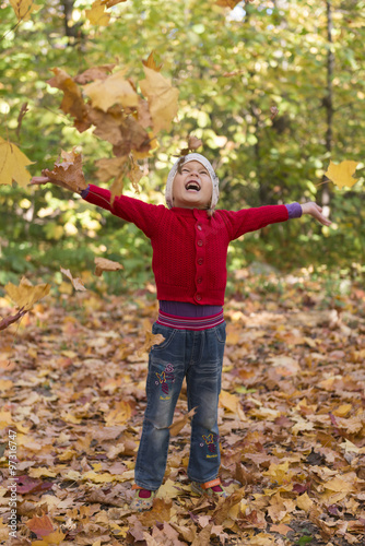 cheerful child among the falling leaves