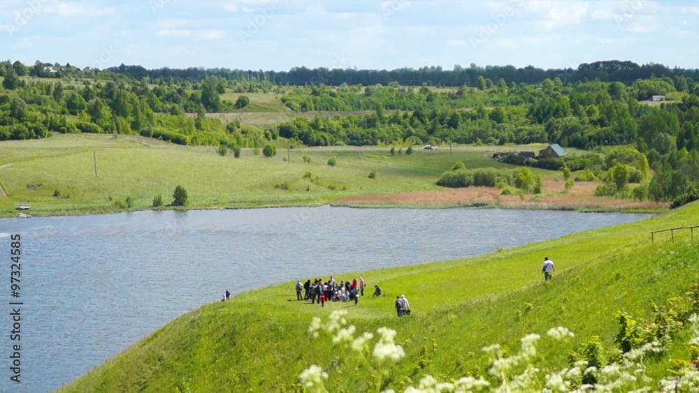 Tourists at the coast of the lake near the ancient Izborsk Tourists at the coast of the lake near the ancient Izborsk
