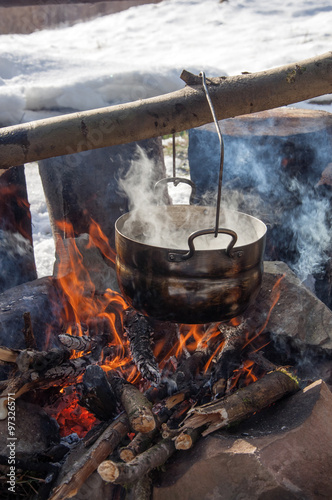 Cooking in field conditions, boiling pot at the campfire on picnic, mountains, 