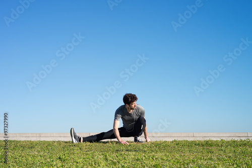 man stretches the leg in the ground space for text