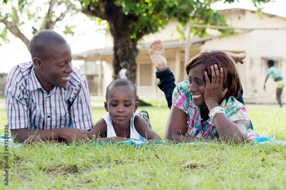 Fototapeta premium Happy family lying in the shade of a tree.