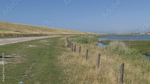 DE PUTTEN, PETTEN, THE NETHERLANDS -  landside of the Hondsbossche and Pettemer Zeewering  + bird reserve in coastal landscape - hold + pan right photo
