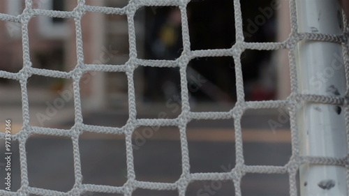 Kid taking practice shots on a hockey net in driveway closeup
