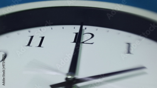 Selective focus (Lens Baby) timelapse of an analog clock going backwards with a zoom and pan effect.