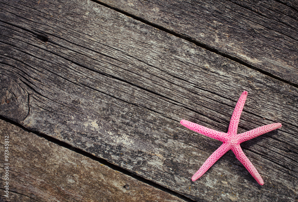 Starfish laying on a pattern on wooden background Starfish laying on a pattern on wooden background